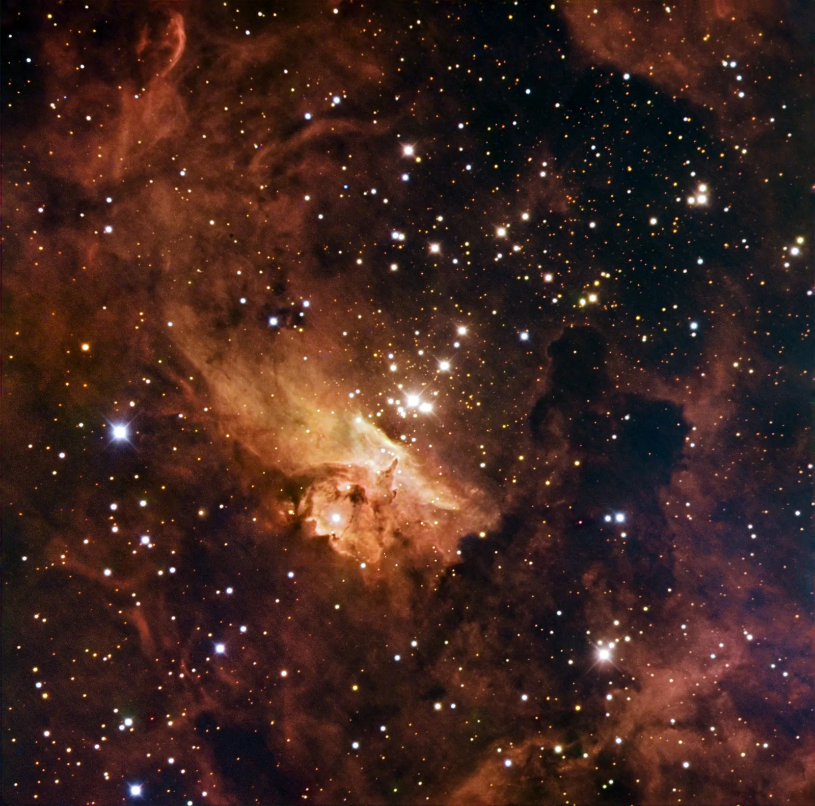 L'amas Pismis 24 : nuages orange et étoiles bleues brillantes