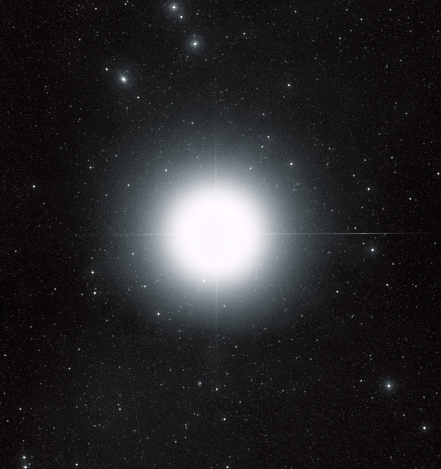 Sirius, étoile très brillante entourée de rayons de diffraction, sur un champ d'étoiles